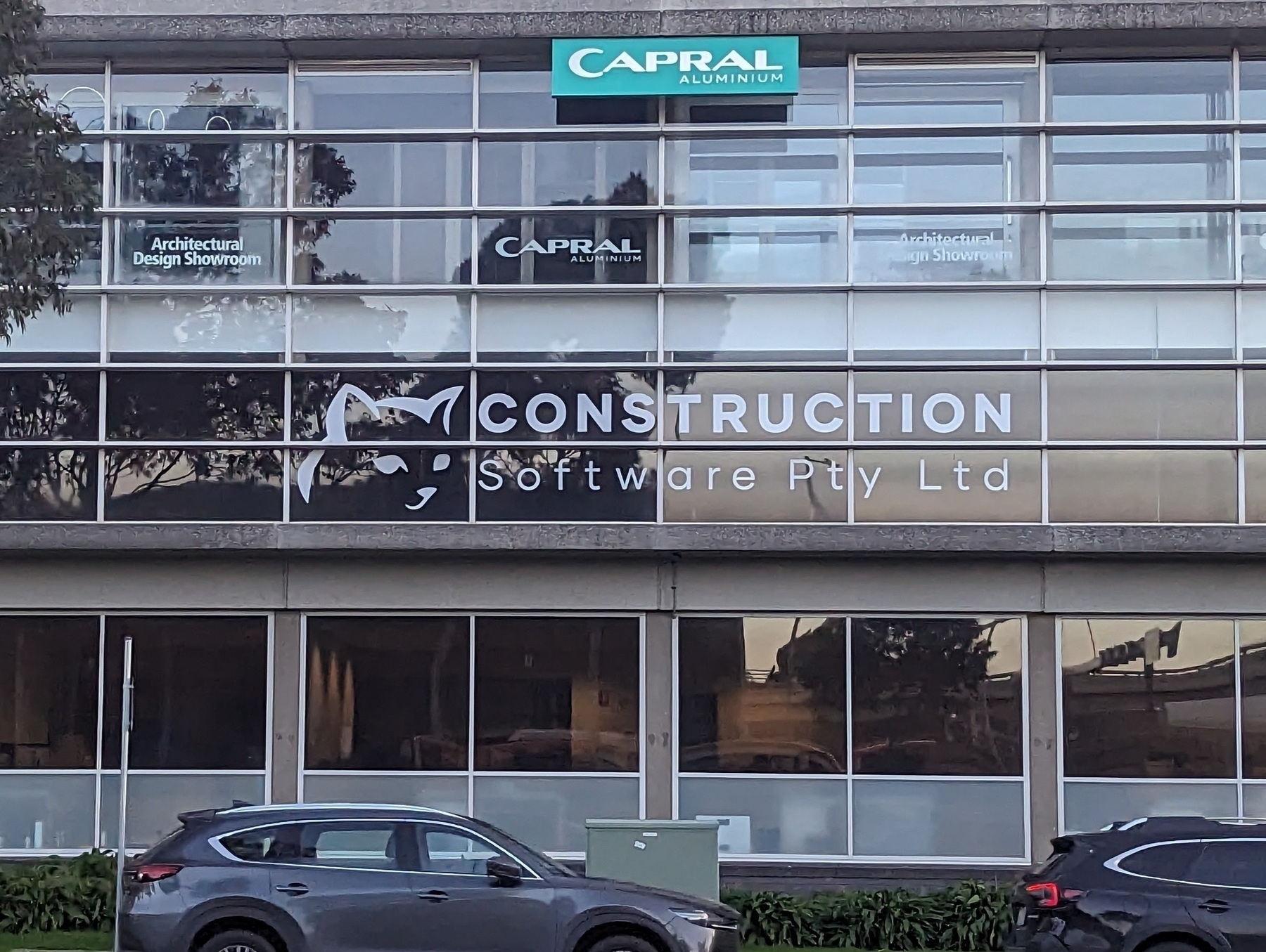 A business sign painted on the side of a glass building that reads: Construction Software Pty Ltd