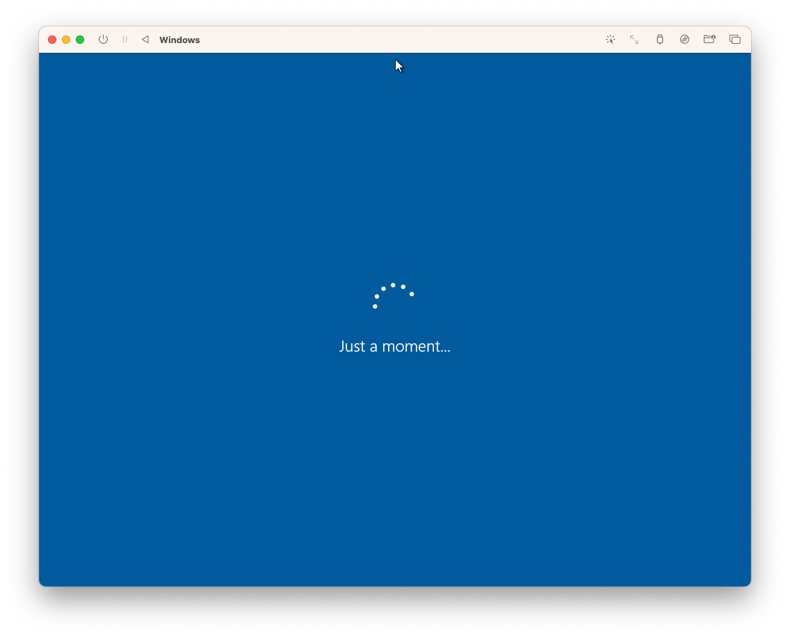 A blue Windows install screen within a MacOS window showing a spinner and the message 'Just a moment…' underneath