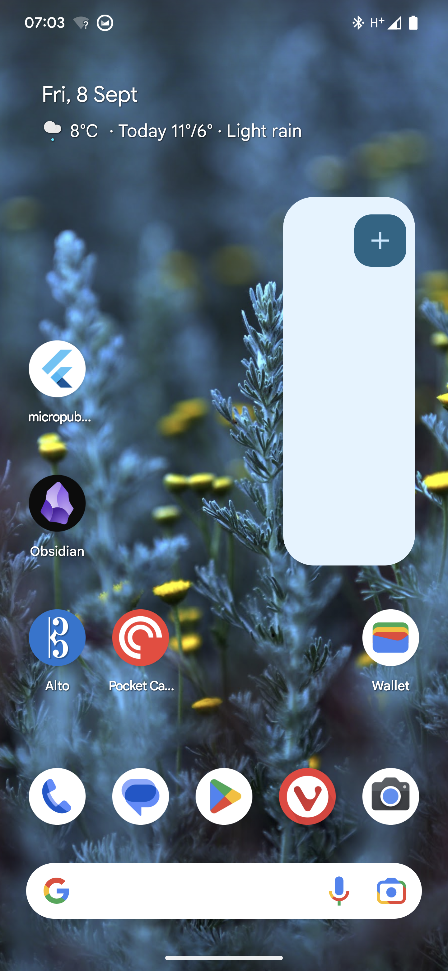 An Android phone screen with the calendar widget on the right that is completely white except for a blue plus button