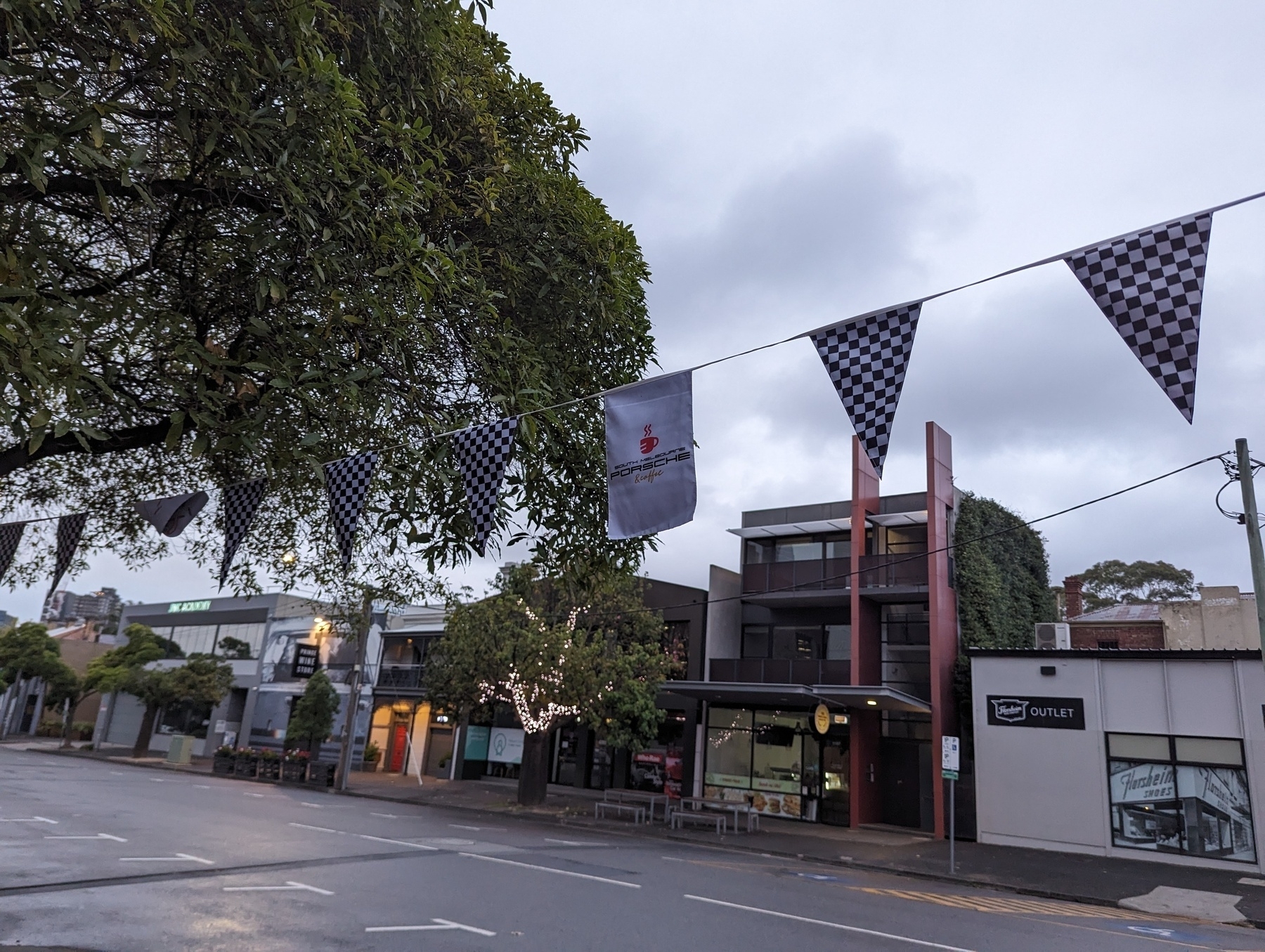 Bunting strung up in the street with a Grand Prix theme, including checkered flags.