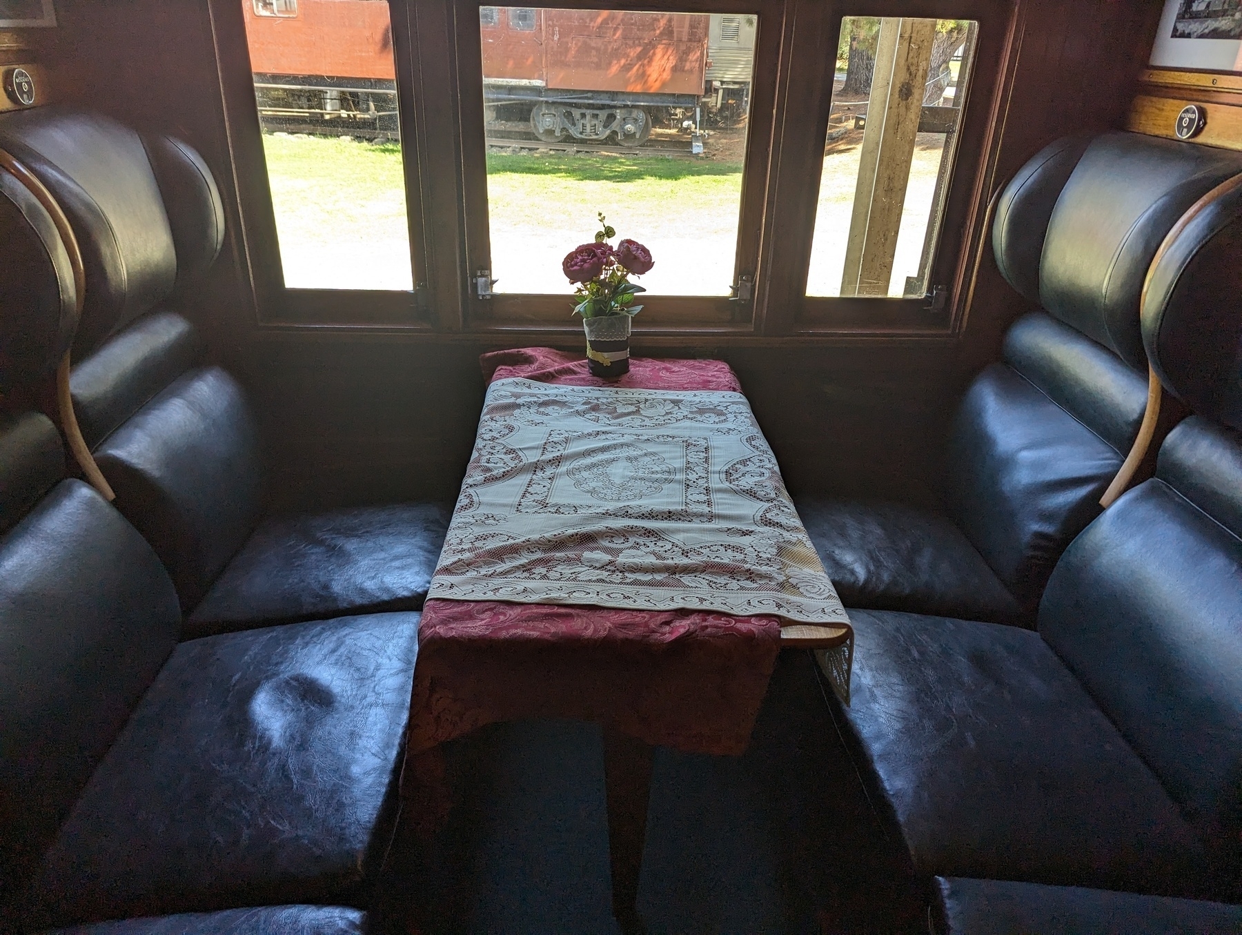 Flowers in a vase on a table in an old fashioned dining car.