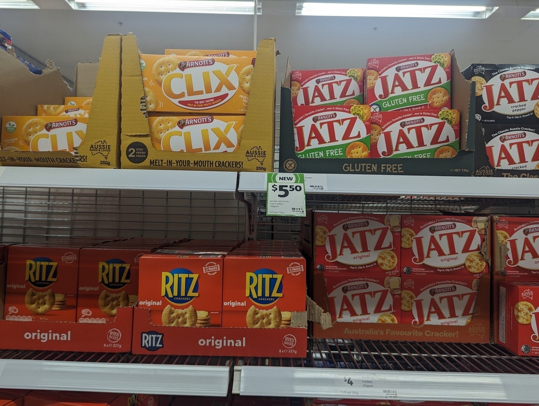Auto generated description: A supermarket shelf displays various brands of crackers, including Arnott's Jatz, Ritz, and Clix, with a price tag indicating $5.50 for one of the products.
