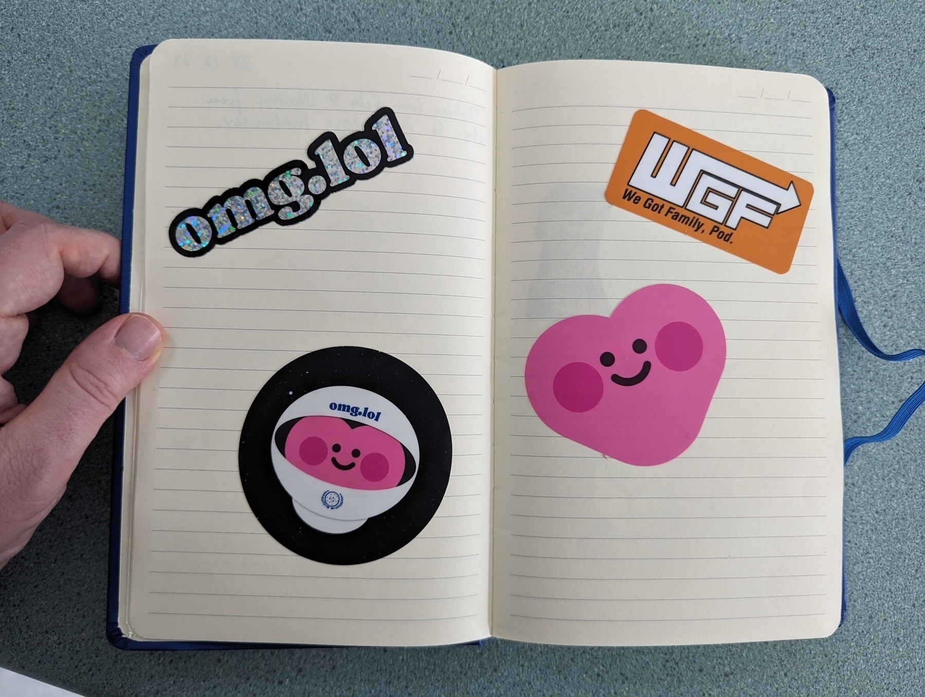 Journal opened up to a double page showing stickers from omg.lol and Robb Knight