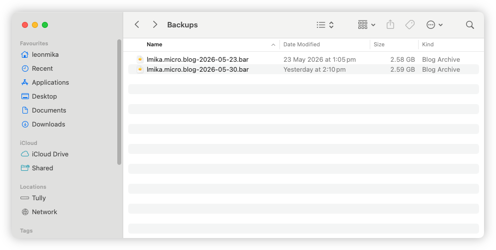 Auto-generated description: A file directory titled Backups contains two backup files, each named lmika.micro.blog with different dates and sizes, showing their locations on the left sidebar.