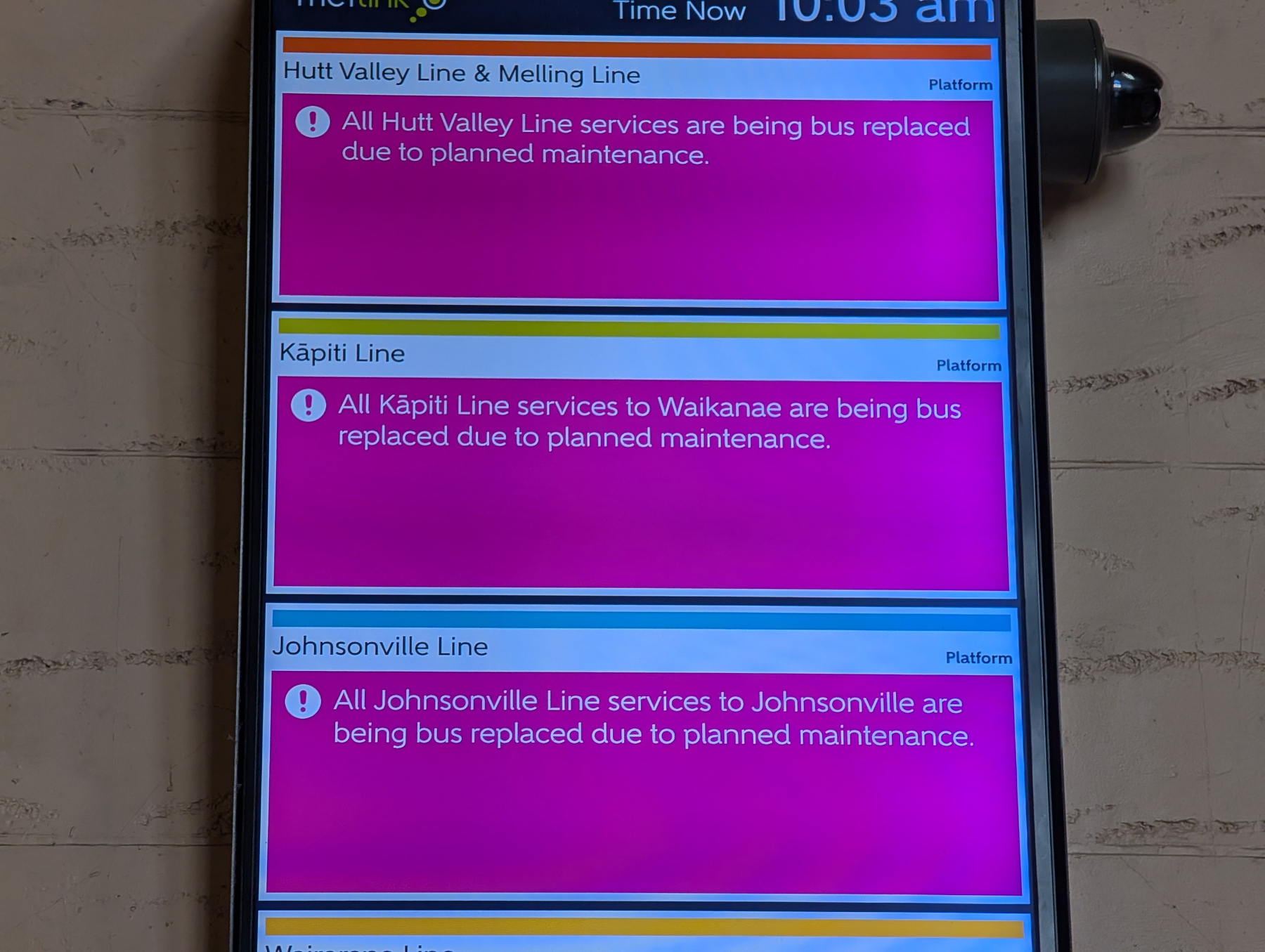 A phone screen displays public transport notices indicating that all services on the Hutt Valley, Kāpiti, and Johnsonville Lines are being replaced by buses due to planned maintenance.