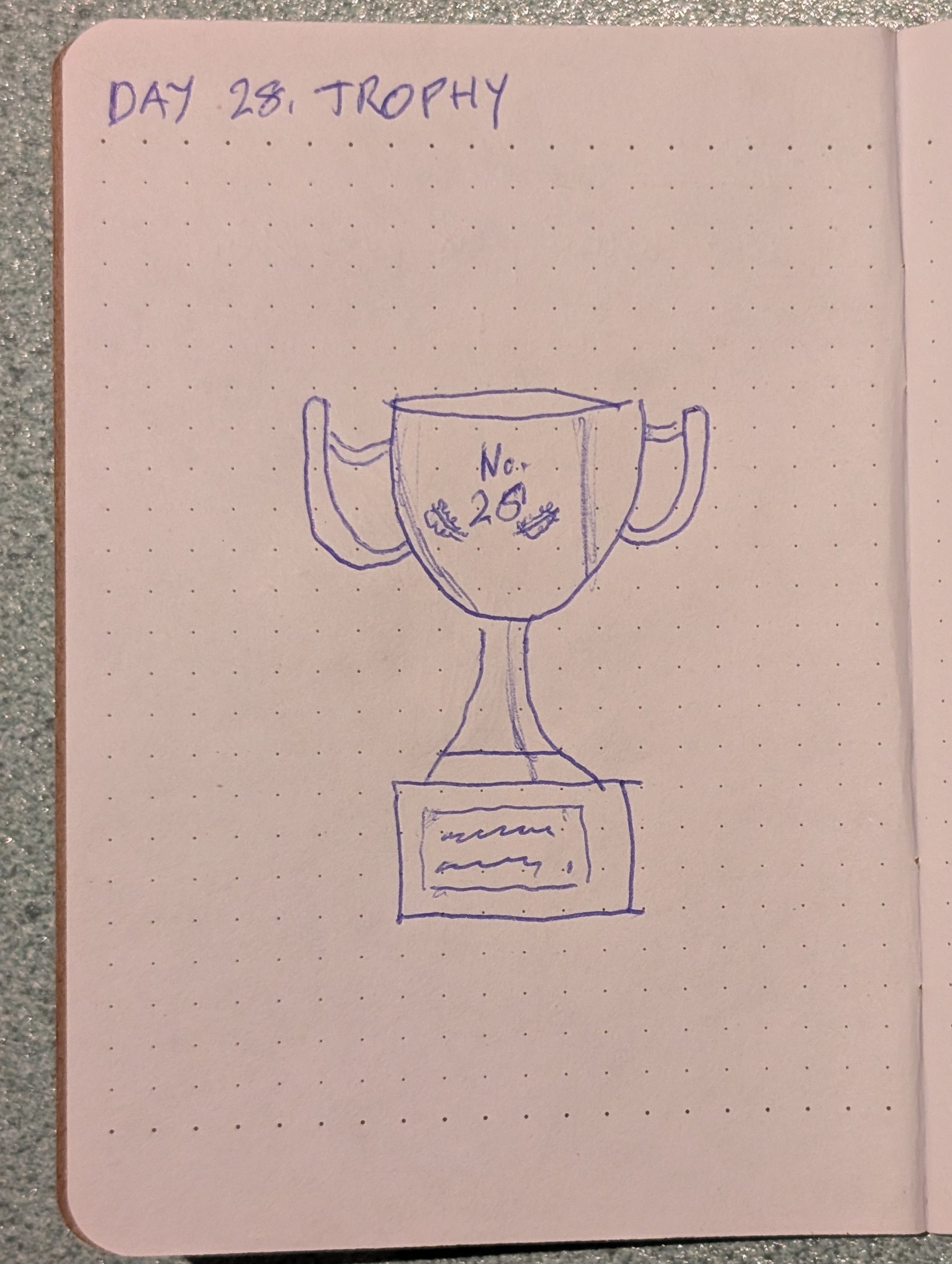 Auto-generated description: A hand-drawn sketch of a trophy labeled No. 28 with handles on both sides and a plaque on the base is shown on a dotted notebook page.