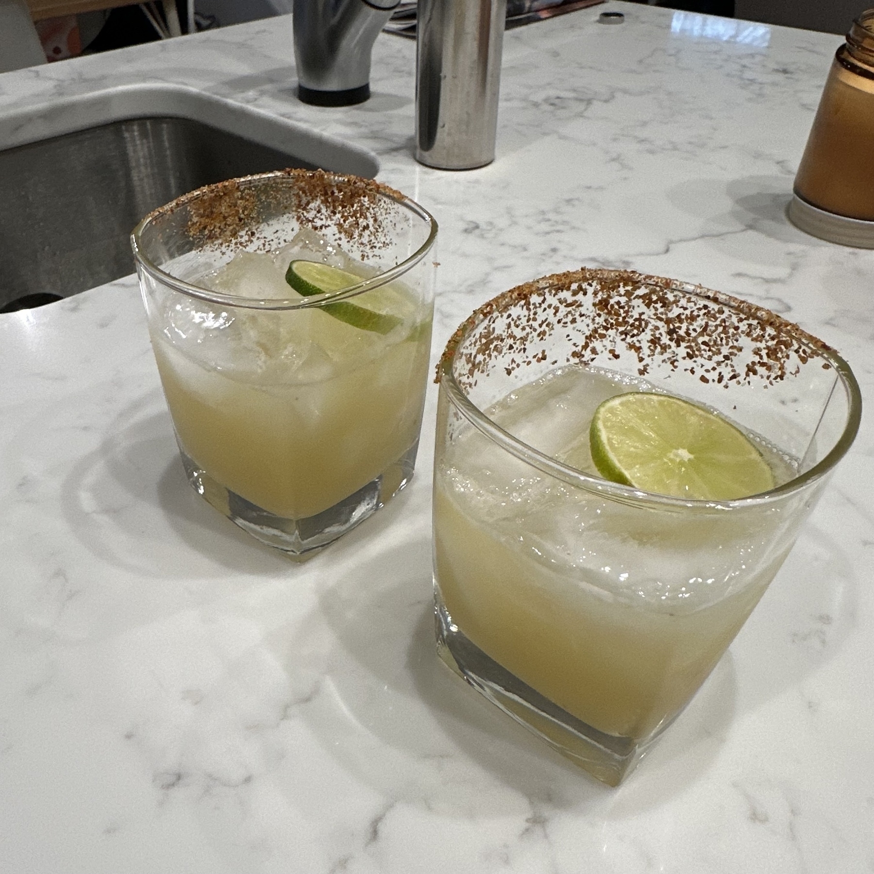 Two margaritas with tajin salted rims.