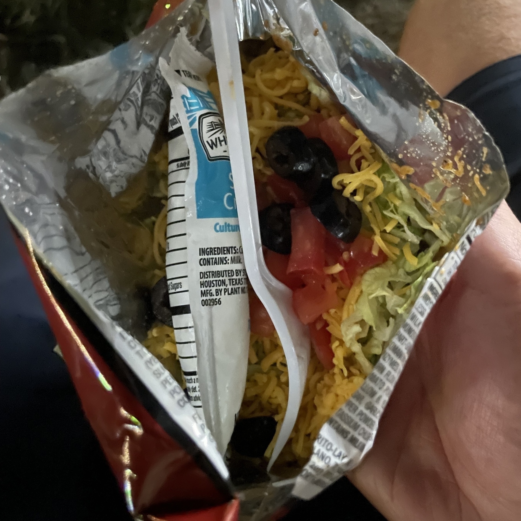 Open bag of Doritos with taco mix inside