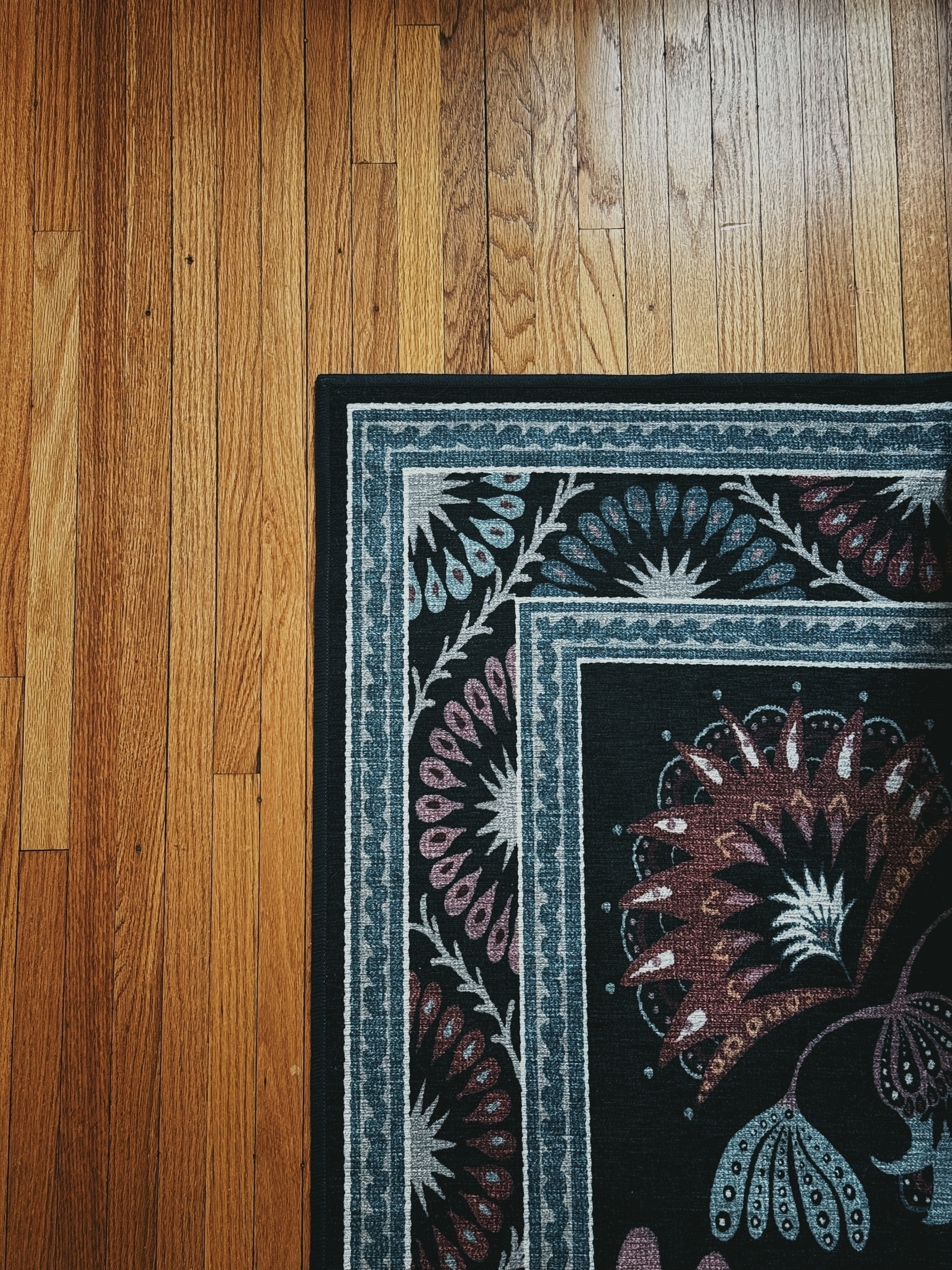 Patterned run in blue and subdued reds against a wood floor