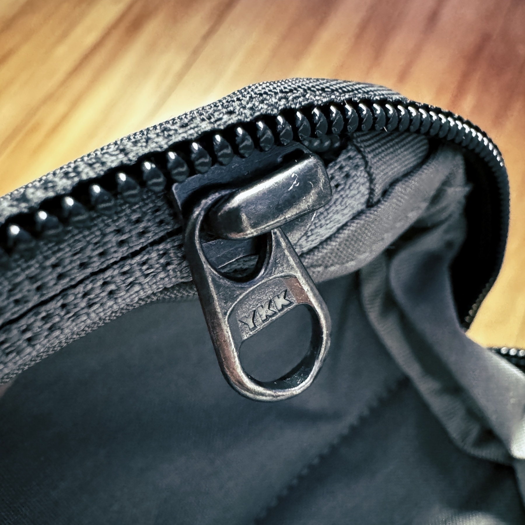 close up photo of a black nylon accessory pouch and a steel YKK zipper