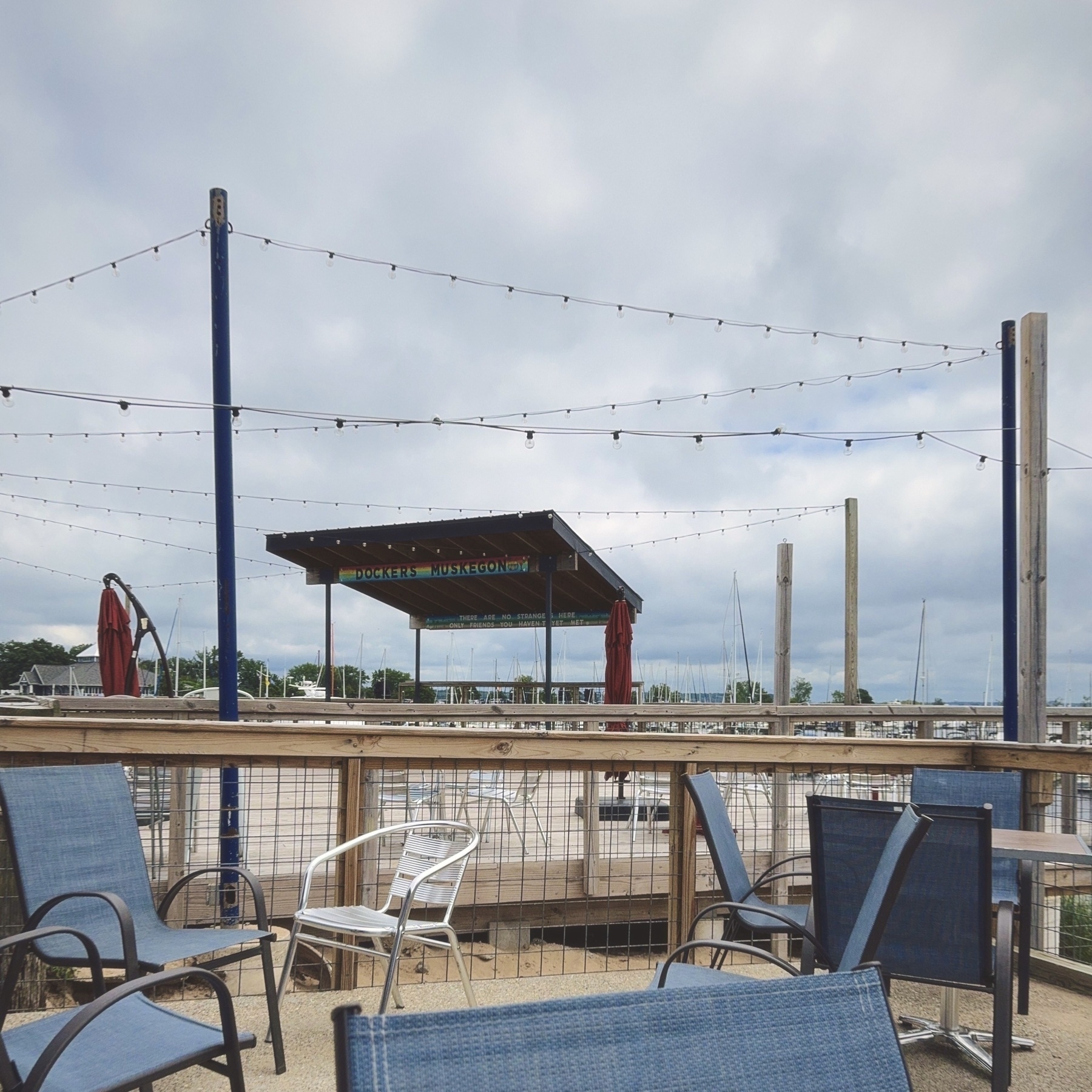 the patio with several chairs and a pergola with the restaurant name Dockers Muskegon in blue
