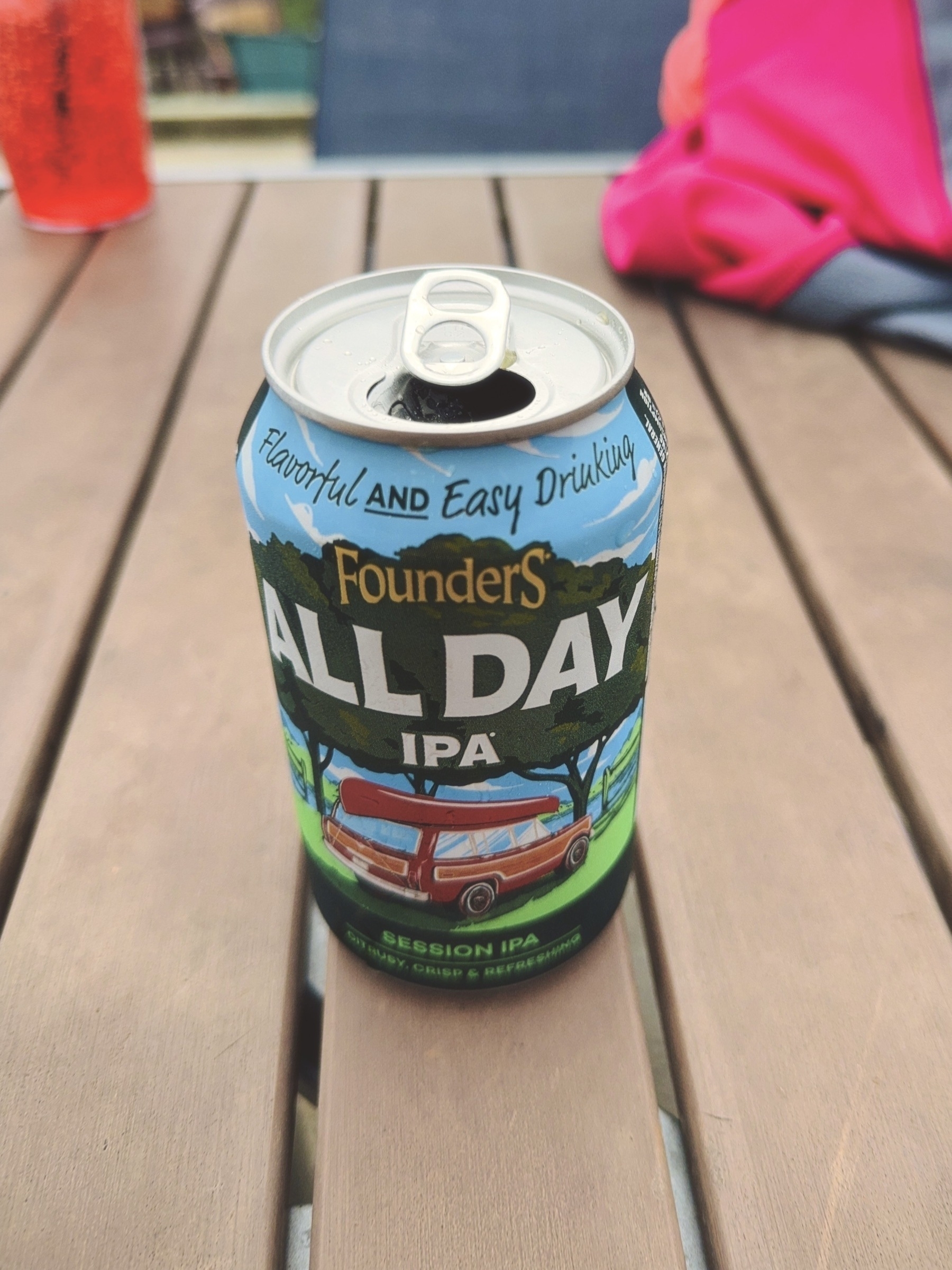 can of Founders All-Day IPA beer atop a wooden outside restaurant table