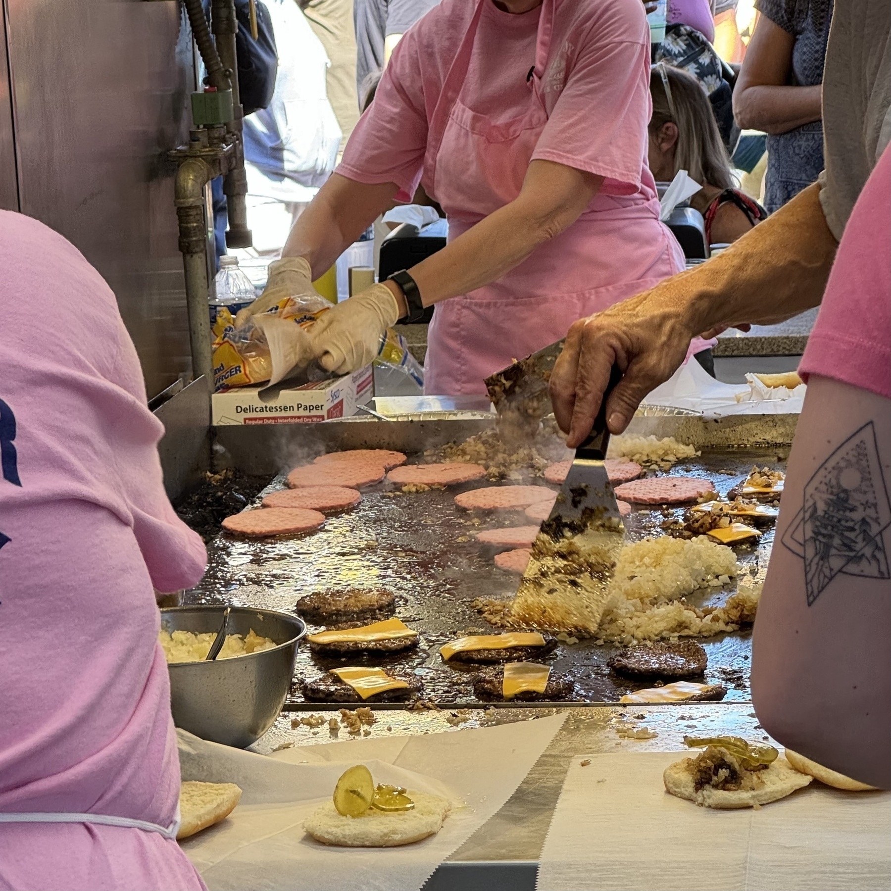 a view into the flat top at Midway Mens club where burgers are being prepped