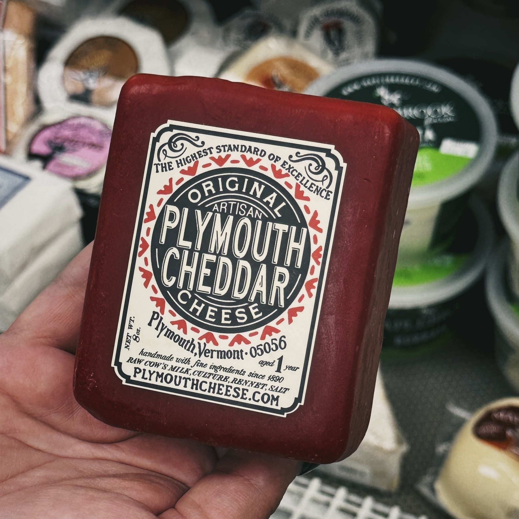 square package of cheese called Plymouth Cheddar in all caps