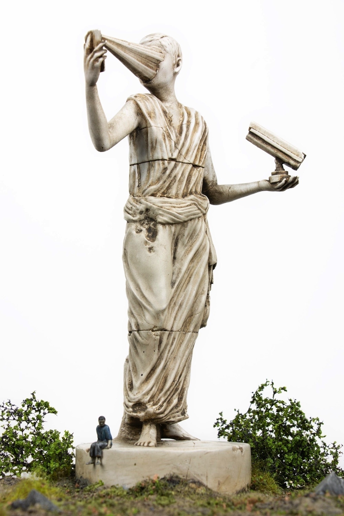 Miniature sculpture artwork depicting a person in a toga looking at a phone device that is piercing their entire face.