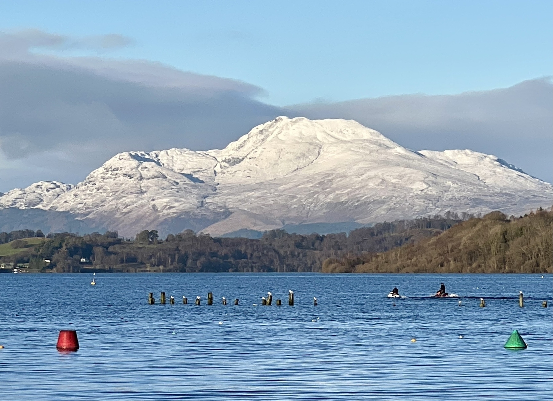 Scottish loch in foreground with snow capped Ben (hill) in the background 