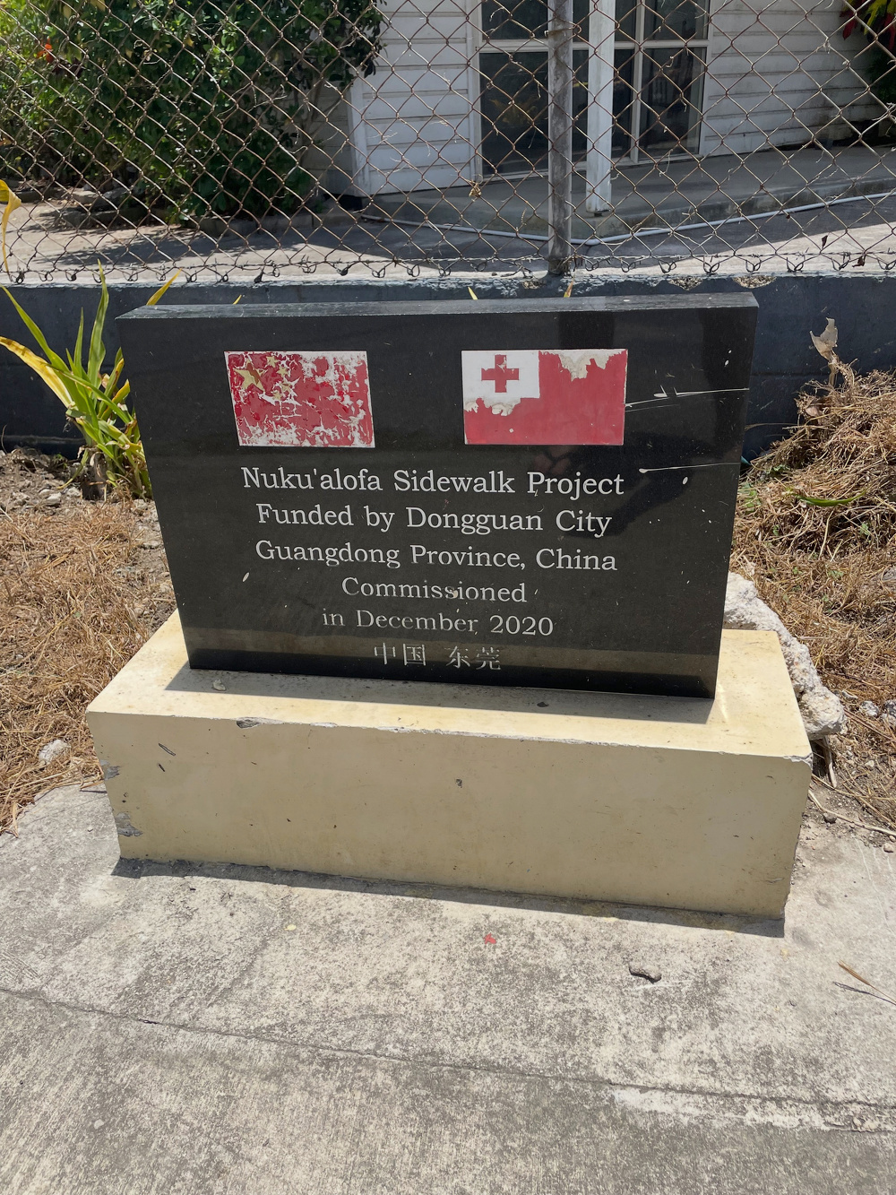 A plaque commemorates the Nuku'alofa Sidewalk Project, funded by Dongguan City, Guangdong Province, China, and commissioned in December 2020, featuring both the Chinese and Tongan flags.