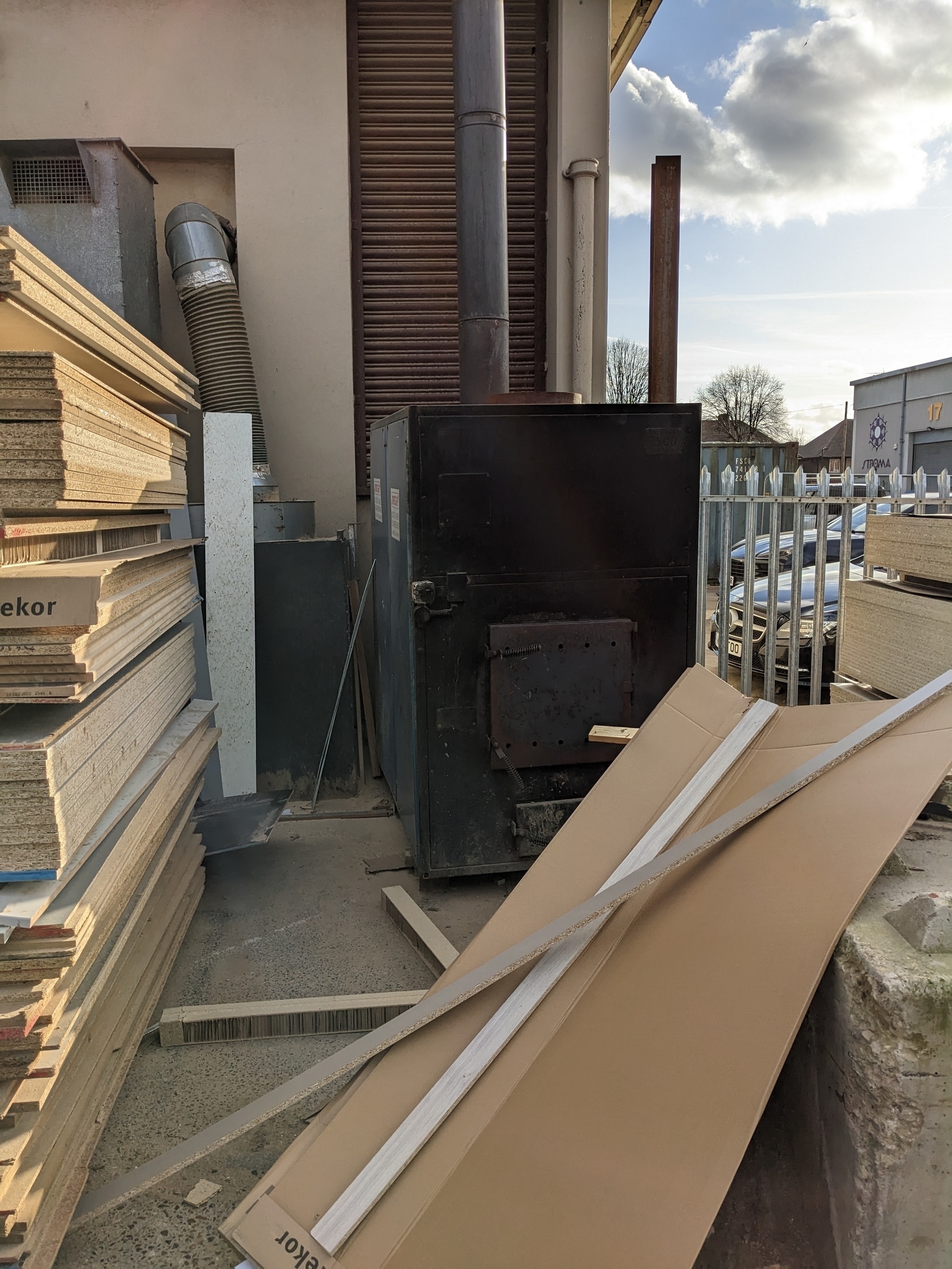 Photos of incinerator chimney covered by corrugated sheets and scaffolding, and not in use.