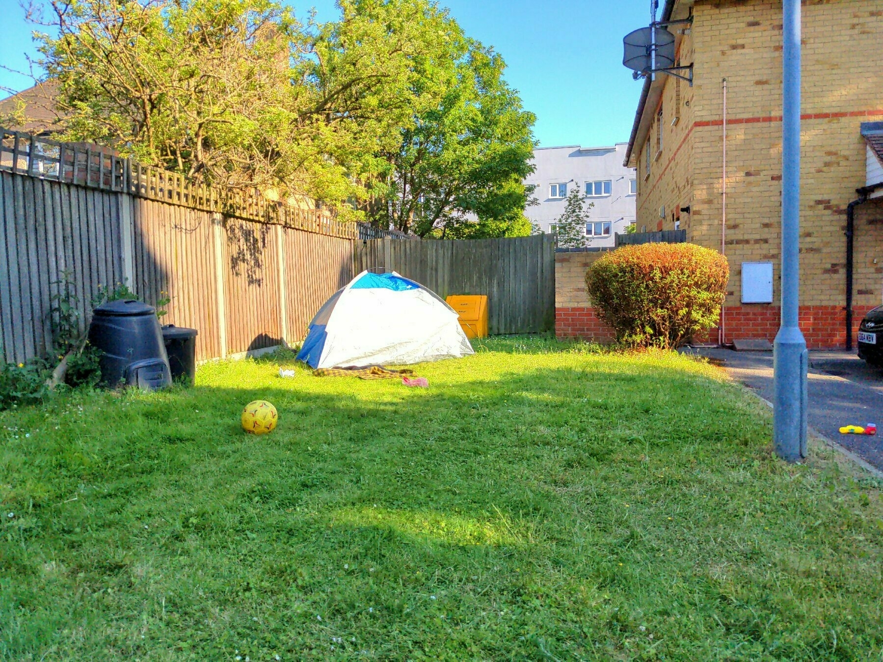View of our communal garden in early evening sunshine with beach tent set up at the far end.