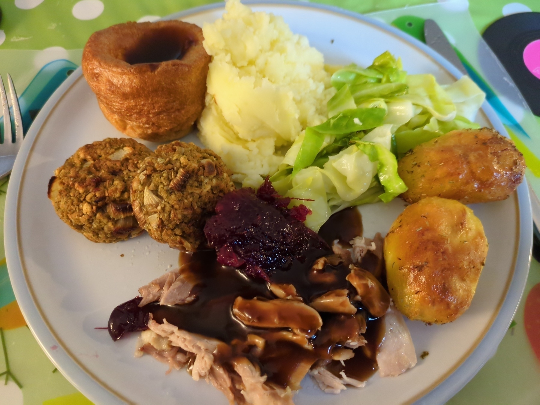 Photo of my dinner on a plate - roast chicken, potatoes and cabbage with stuffing balls, mashed potato, Yorkshire pudding, gravy and cranberry sauce 