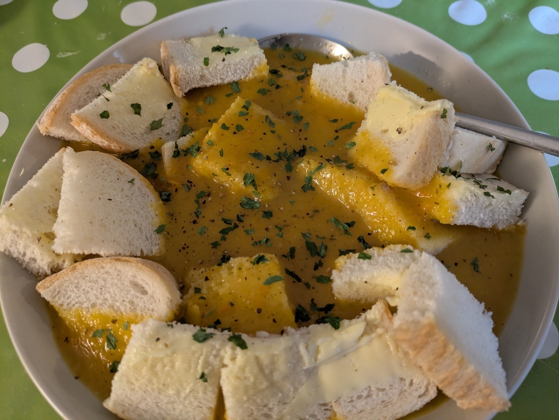 A bowl of carrot and coriander soup with bread and butter croutons 