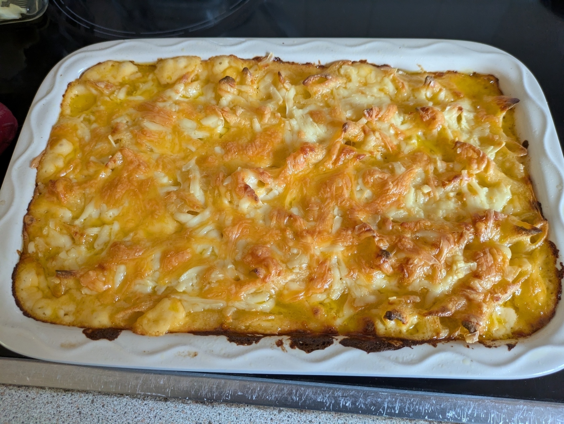 A baked casserole topped with melted cheese in a rectangular dish.