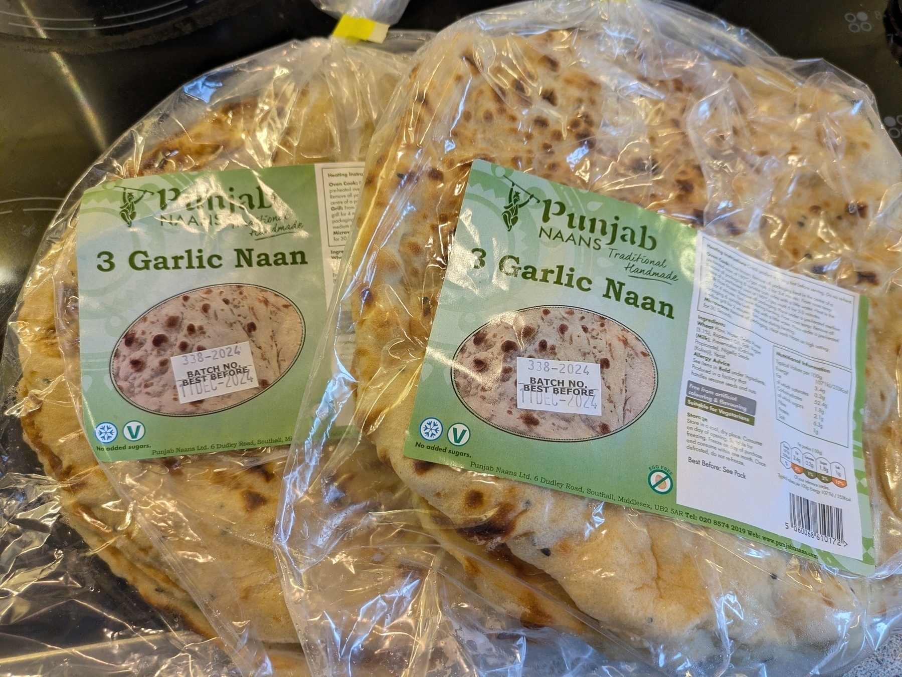 Auto-generated description: Two packages of Punjab Naans, each containing three garlic naan breads, are wrapped in plastic.