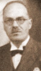 Auto-generated description: A vintage black-and-white portrait of a man wearing glasses and a bow tie.