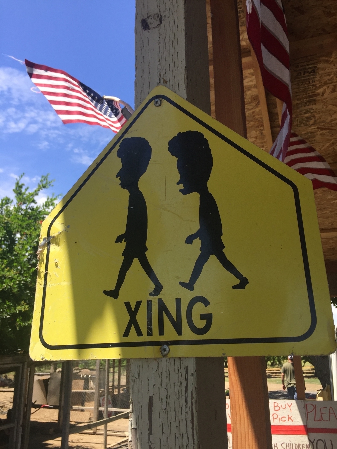 A street sign with the word xing and a silhouette of beavis and butthead  