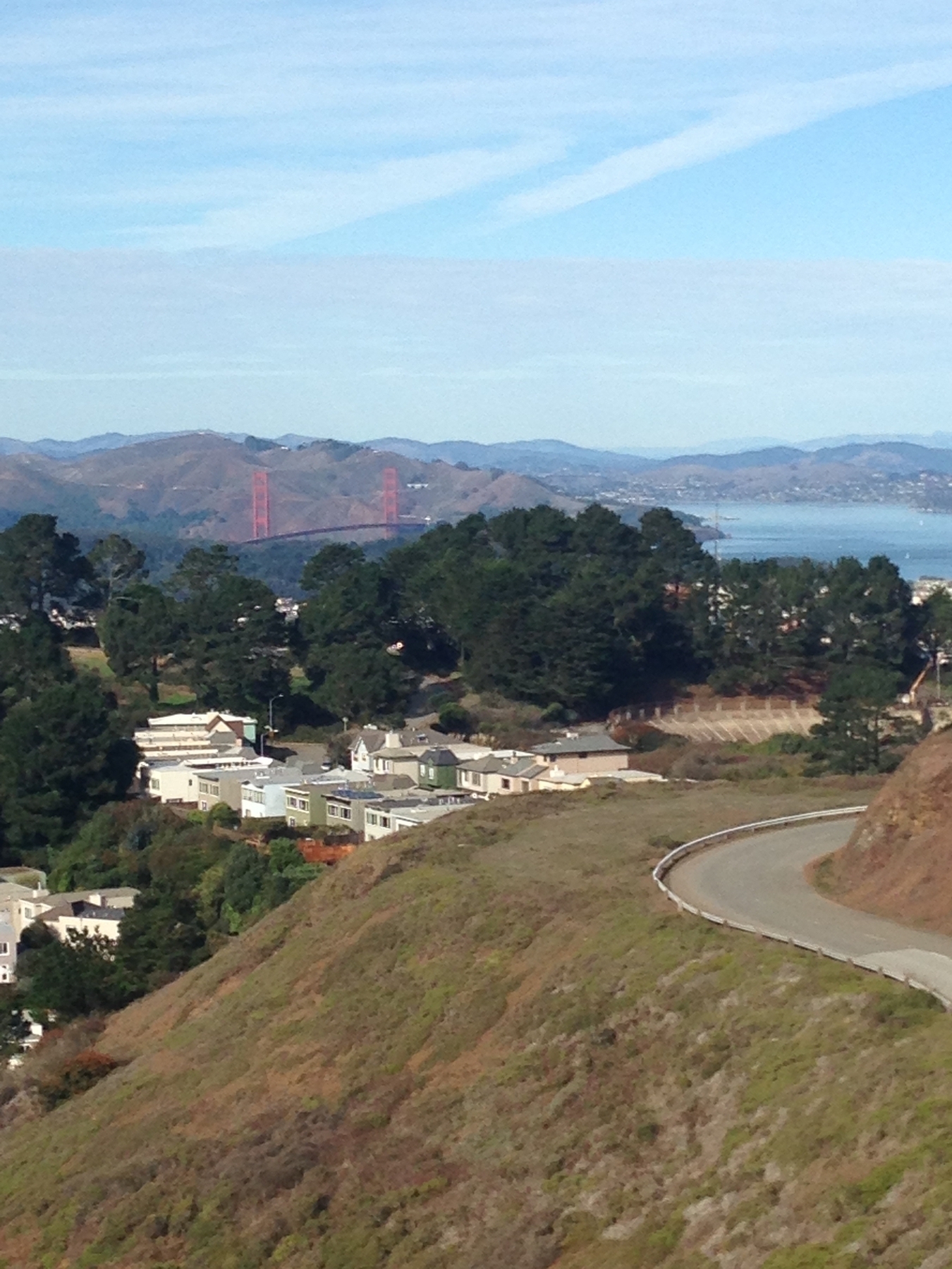 A strip of road on the left, the ocean in the background together with the Golden Gate Bridge in San Francisco, California 