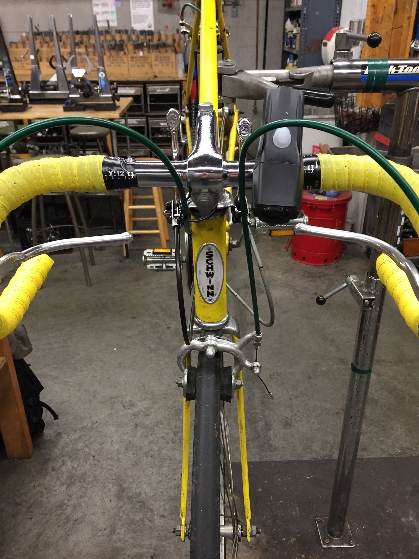 A yellow bike fixed on a bike stand for maintenance 