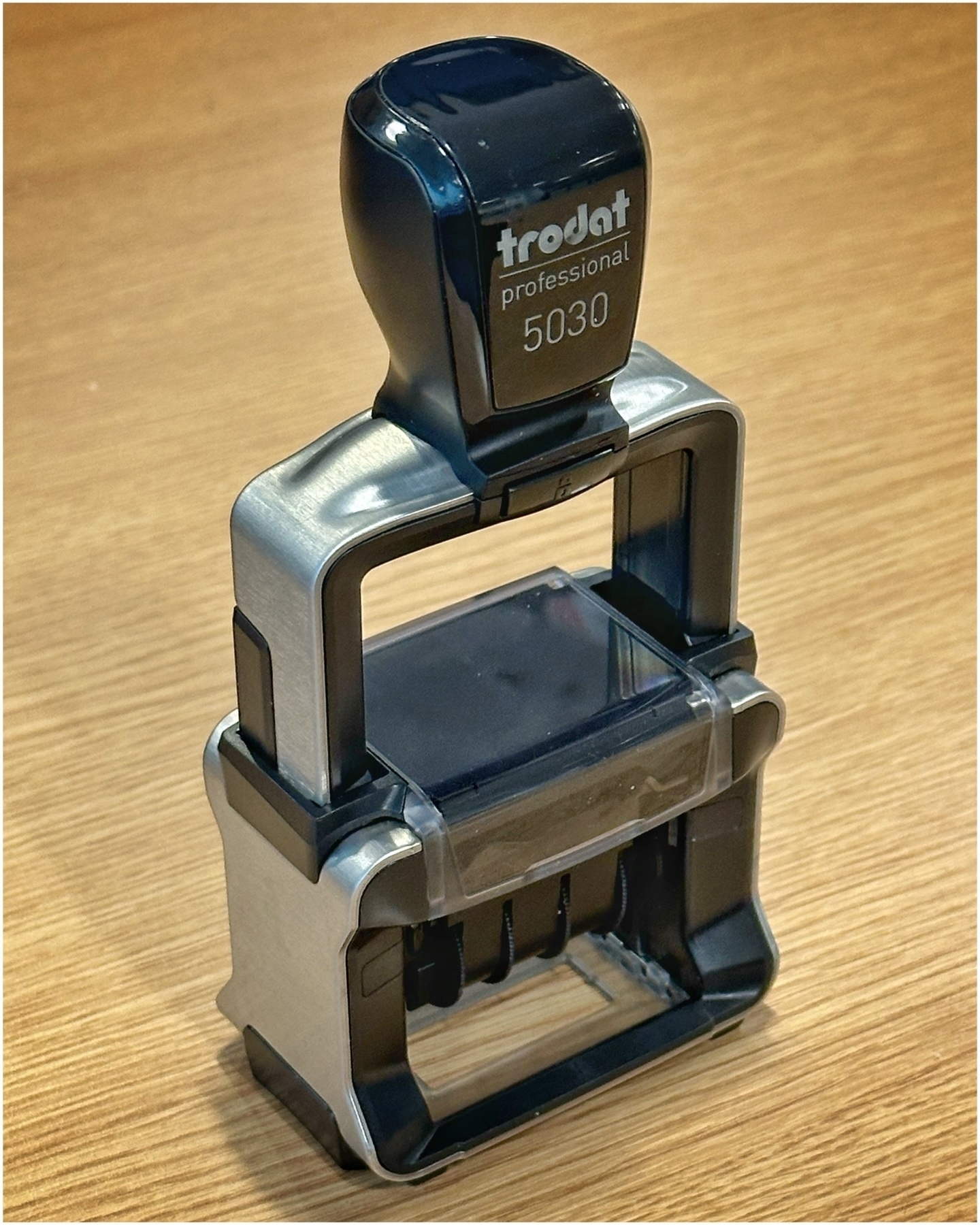 A Trodat Professional 5030 self-inking stamp placed on a wooden surface.