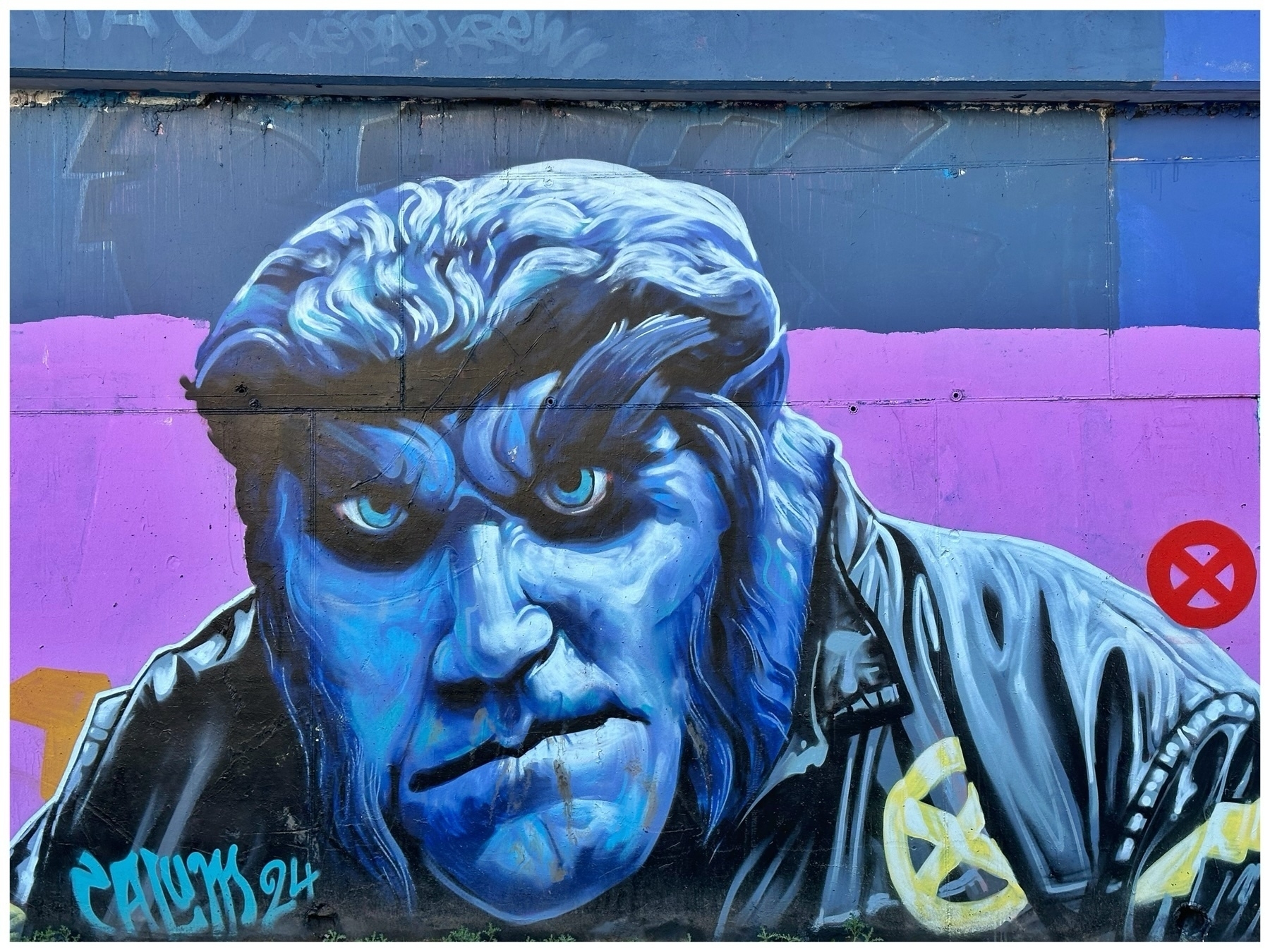 Graffiti art of a person with intense gaze, depicted in shades of blue on a wall with pink and blue sections. There's a no-entry sign symbol in red on the right. Artist's signature "CALUM 94" at the bottom