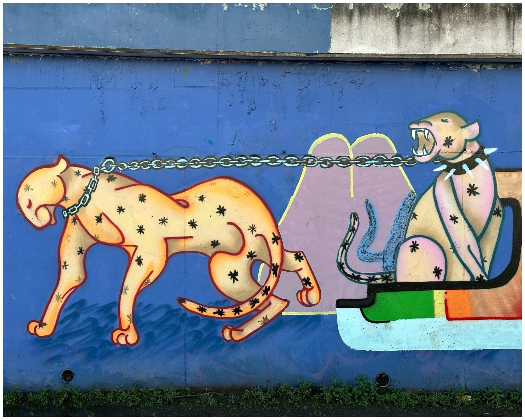 Graffiti depicting two stylized, panther-like creatures connected by a chain. The creature on the left, in a calm posture, has a chain collar. The one on the right is in an aggressive stance, showing its teeth.