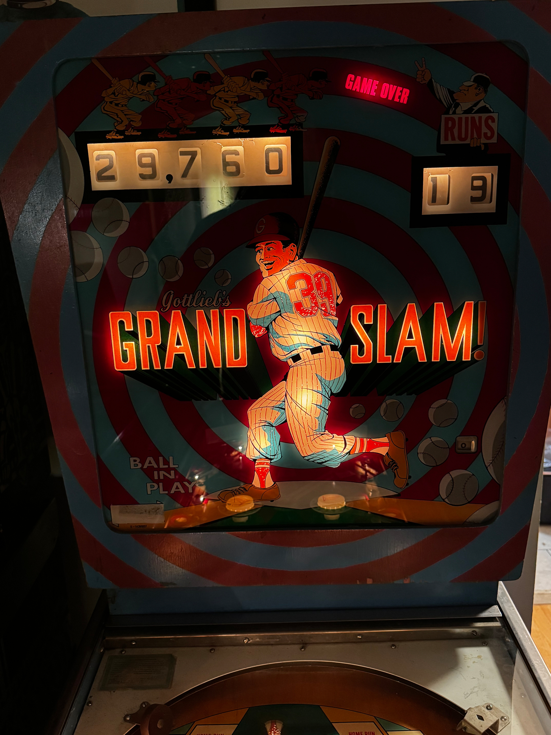 A vintage pinball machine with a baseball theme displays a score and the title Grand Slam! in bright colors.