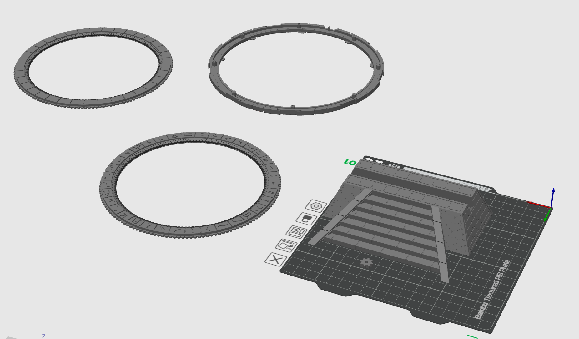 A 3D modeling software interface displays designs for three circular rings and a base with a stair-step pattern.