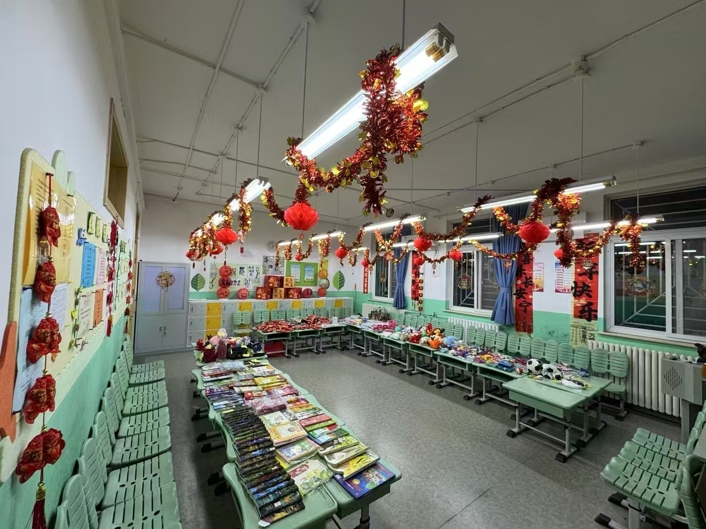 Hamer's school had a charity sale event today. (A decorated classroom features neatly arranged tables with books and toys, adorned with festive red and gold hanging decorations.)