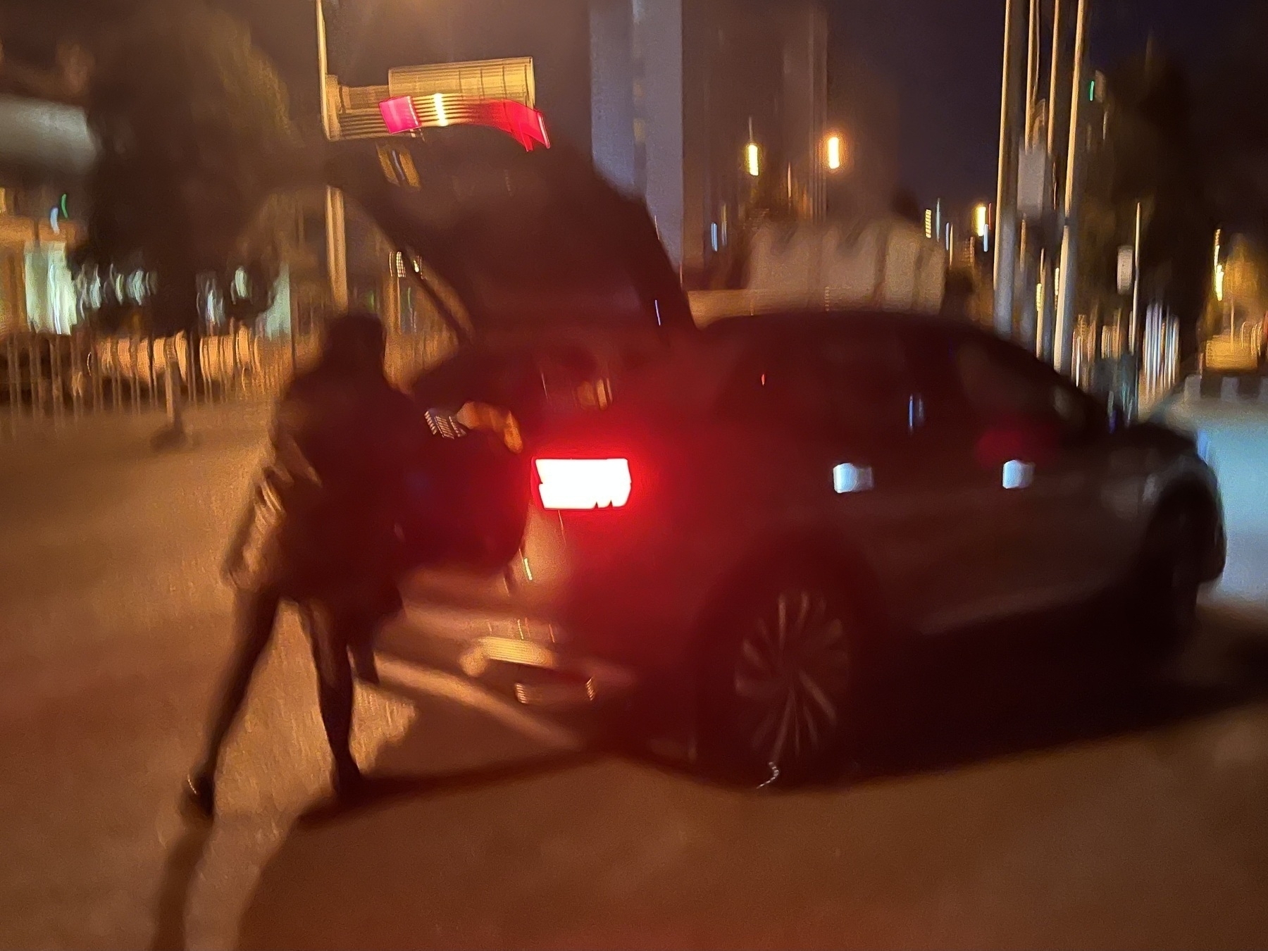 Around 2 AM, Xiaoyan returned home. (A person is loading the trunk of a car parked on a street at night.)