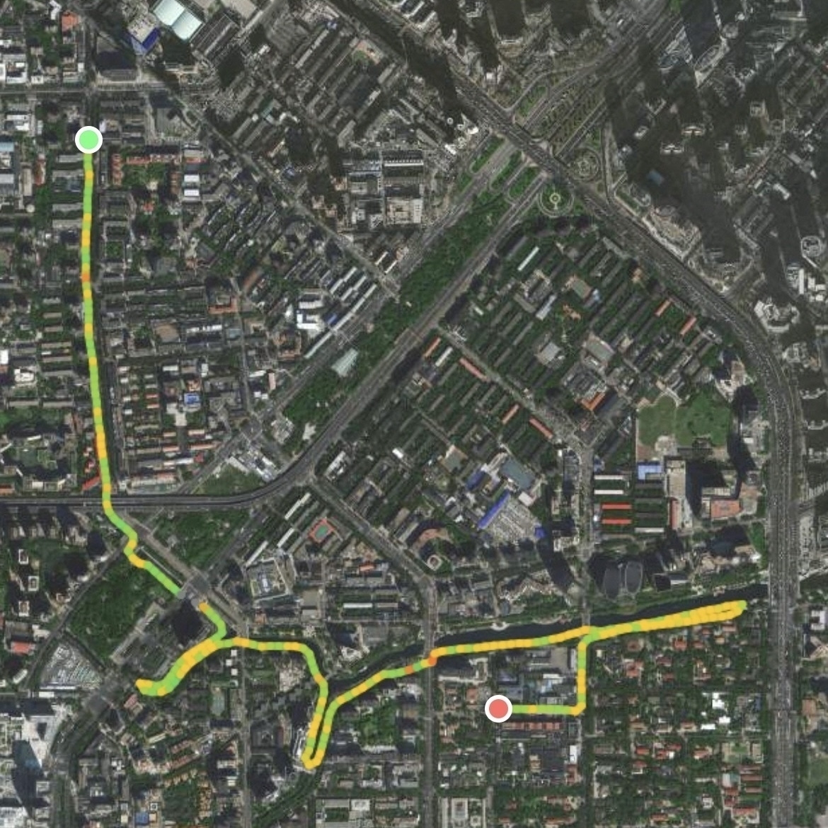 A satellite map displays a route marked with green, yellow, and red lines winding through city streets.