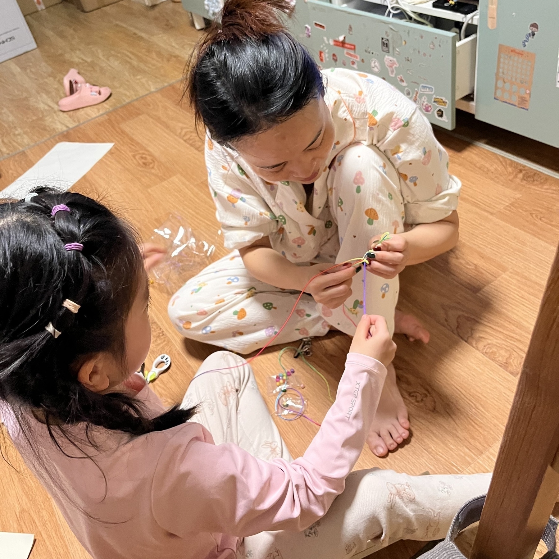 Xiaoyan is teaching Hamer how to weave a hand bracelet.