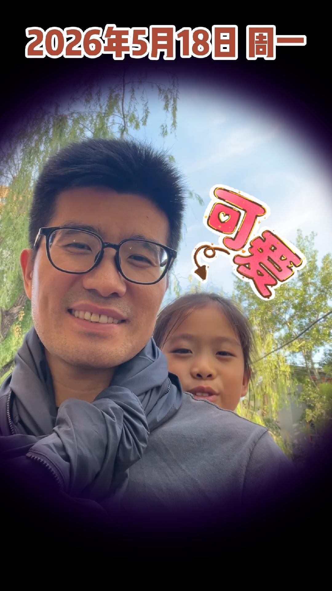 A man with glasses and a child are smiling outdoors, with playful text and graphics surrounding them.