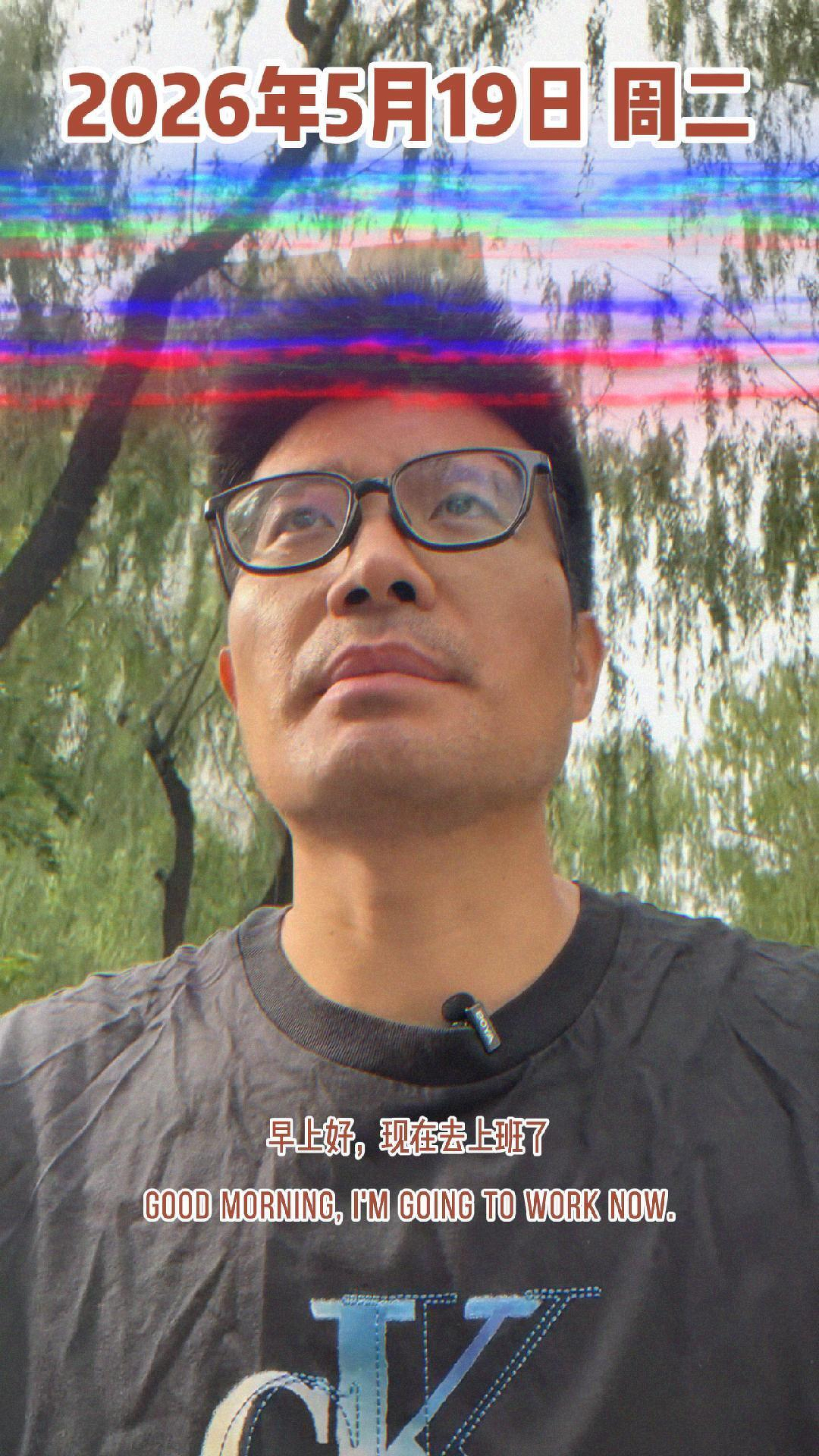 A person wearing glasses is looking up while outdoors with a date and text in multiple languages overlaid on the image.