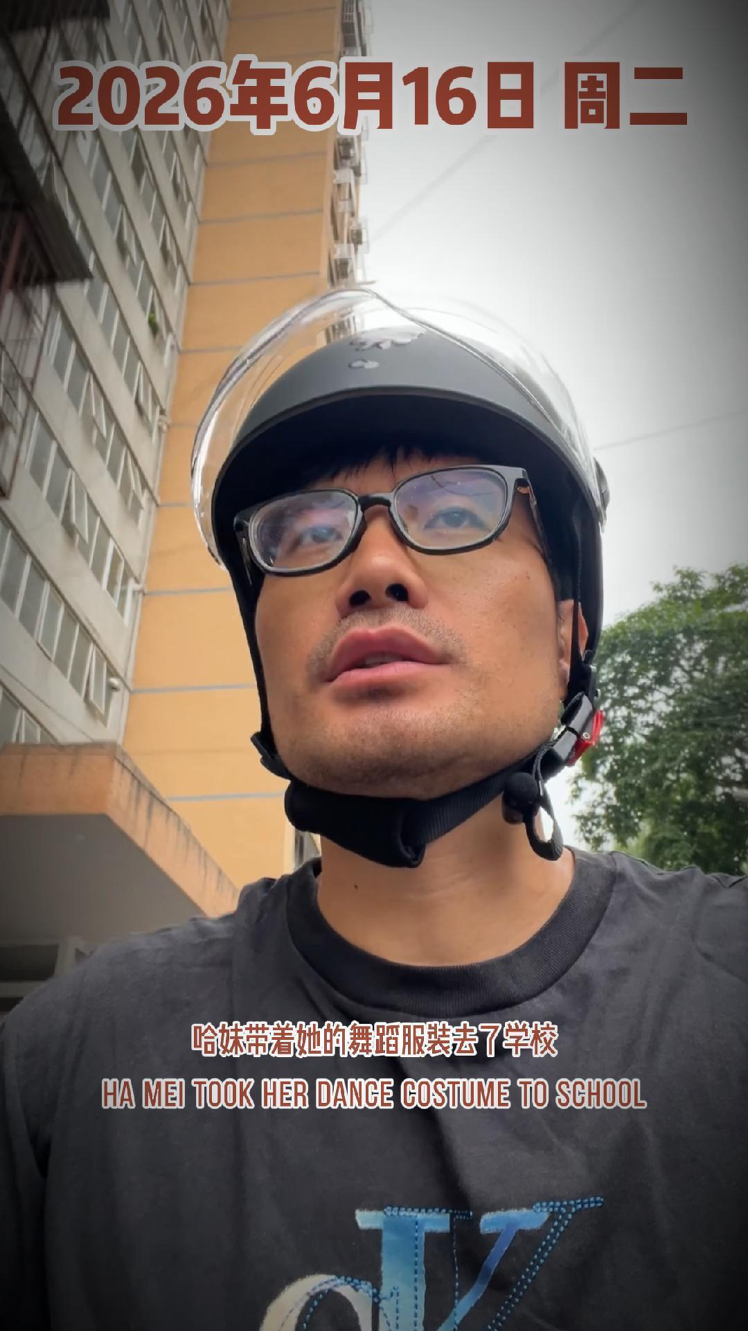 A person wearing a helmet and glasses stands outside a building, with text above and below them.