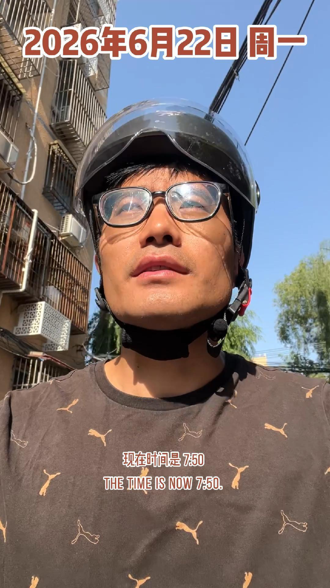 A man wearing glasses and a helmet is outdoors in front of a building with the date June 22, 2026, and the time 7:50 displayed on the image.