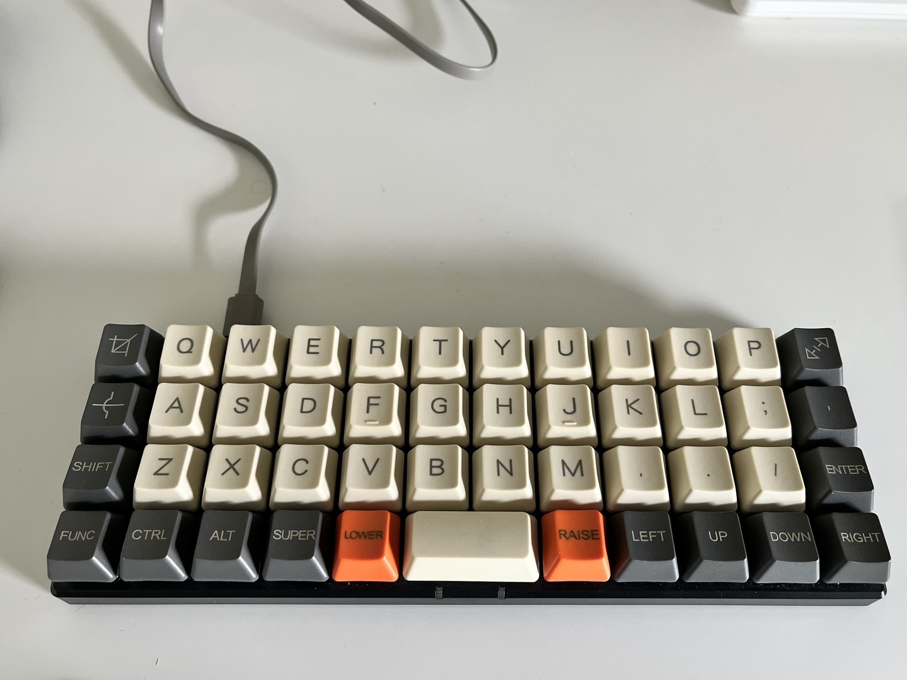 Planck EZ keyboard with gray-glue, beige, and orange key caps