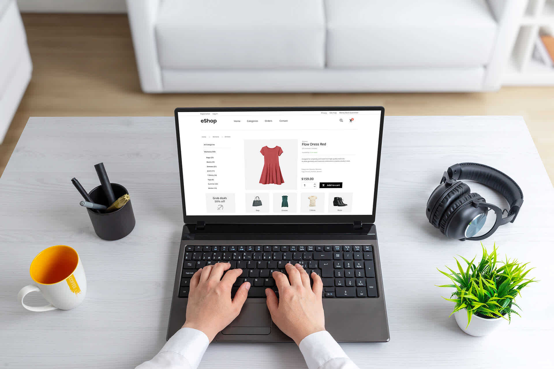 Auto-generated description: A person is browsing a red dress on an online shopping website using a laptop on a desk with a cup, headphones, a pen holder, and a small plant.