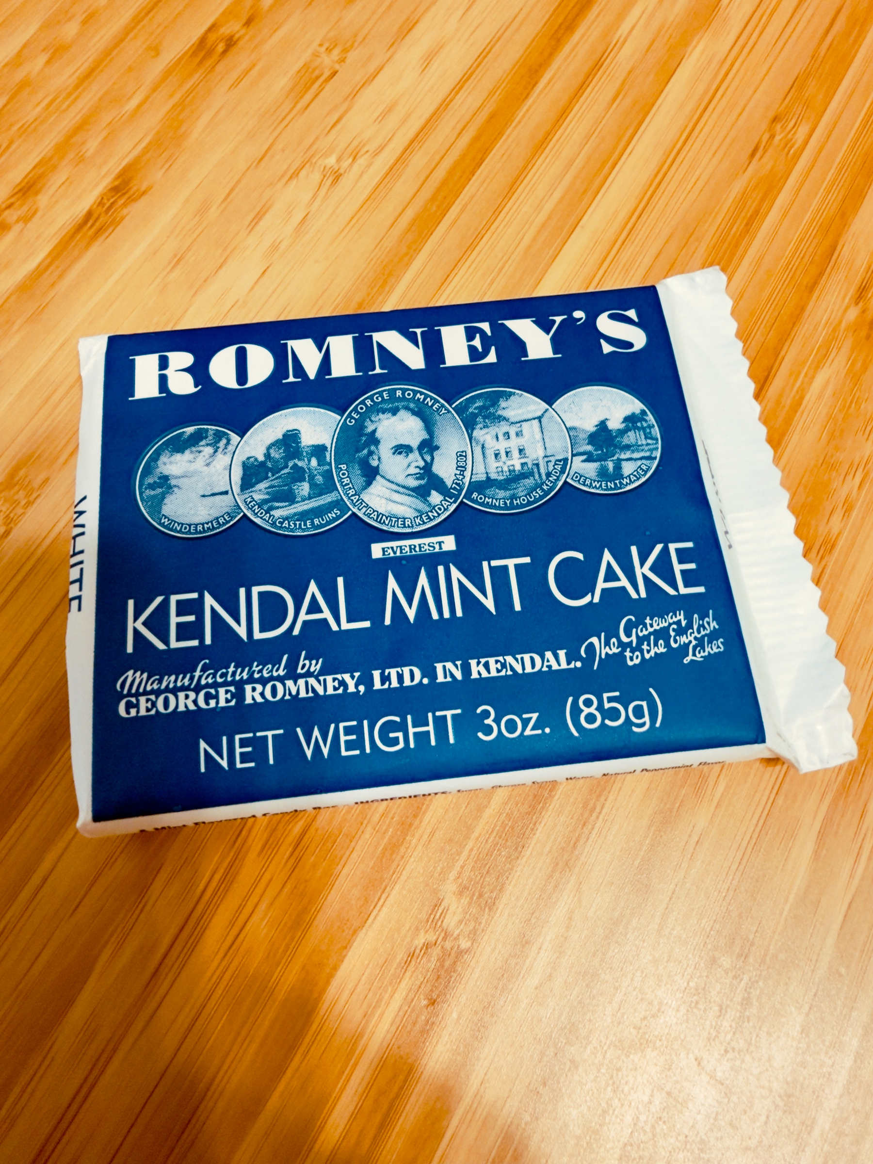 A package of Romneys Kendal Mint Cake is displayed on a wooden surface.