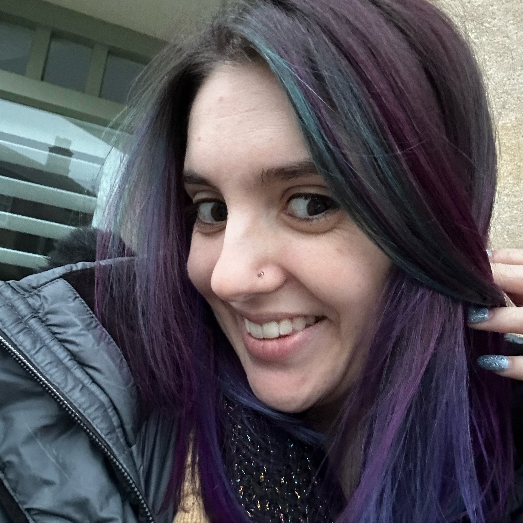 me smiling with blueish purple hair, some more purple streaks, and some teal streaks
