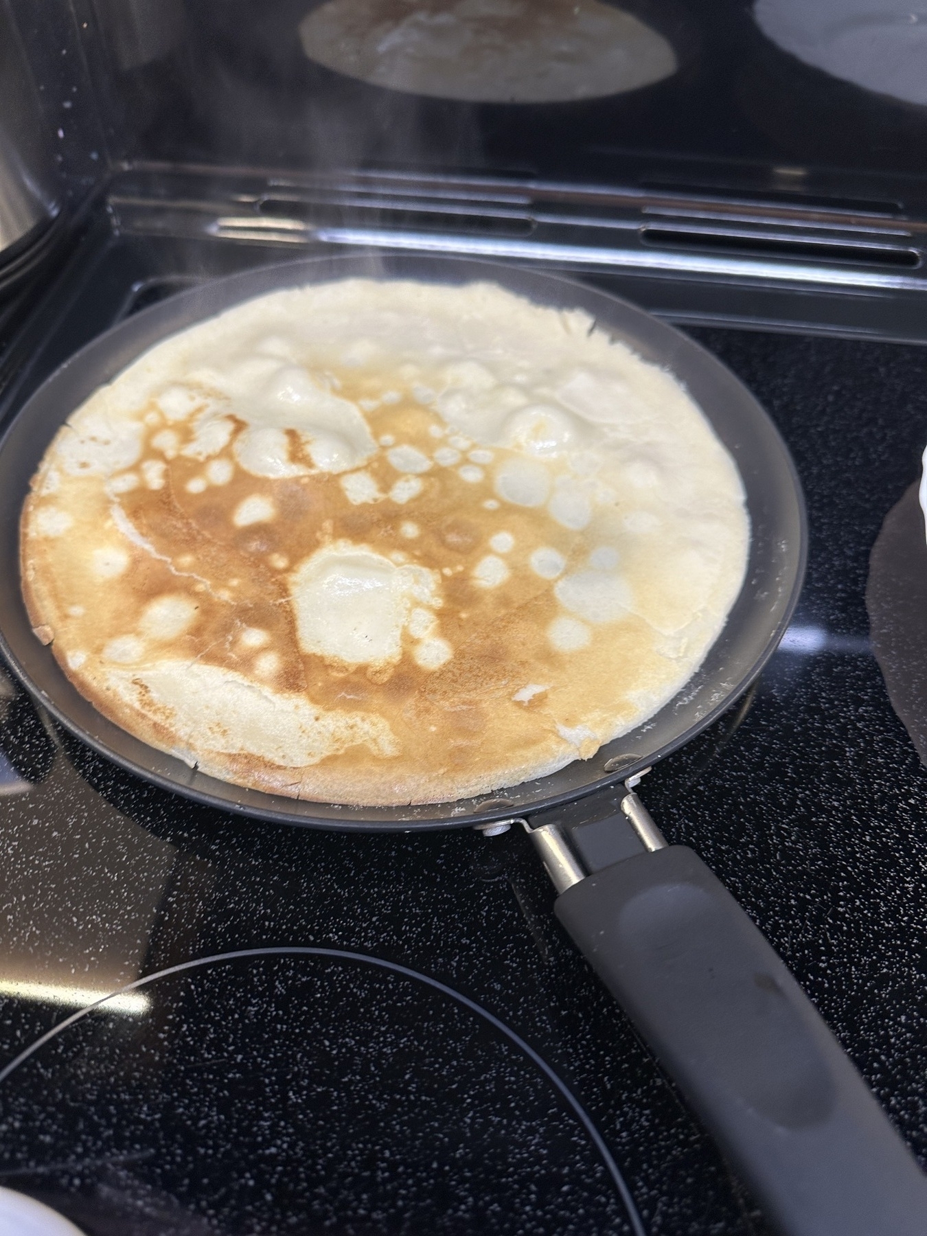 Crepe like pancake in a pan on the stove