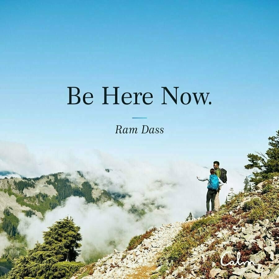 person hiking on a mountain with the words "be here now"